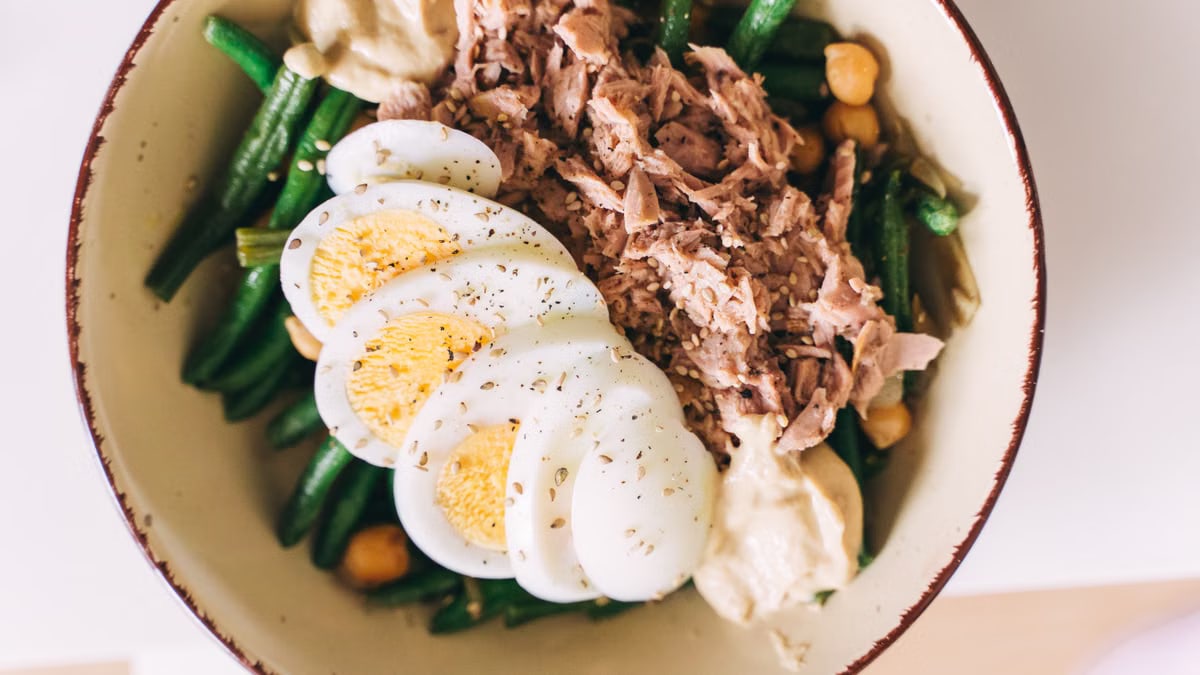Delicious protein-packed bowl featuring tuna, boiled eggs, green beans, and hummus.